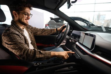 Gülümseyen adam otomobil kiralama seçenekleriyle araba satın alan neşeli müşterileri ziyaret ediyor.