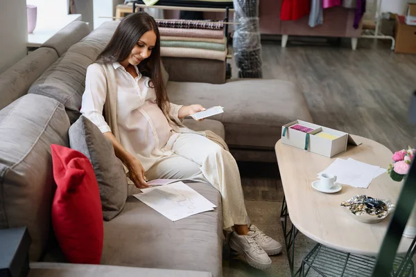 女性在设计工作室学习服装草图 她坐在舒适的沙发上 — 图库照片