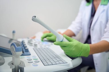 Klinikteki bulanık hamile kadına ultrason yapan kadın jinekoloğu kullanarak ultrason cihazlarının ön planına odaklan. Hamilelik testi kavramı