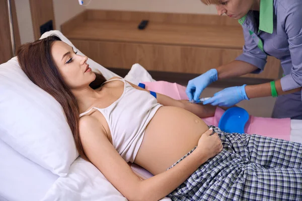 部分女护士在医院的病床上给年轻的高加索孕妇注射注射器 怀孕和生育的概念 — 图库照片