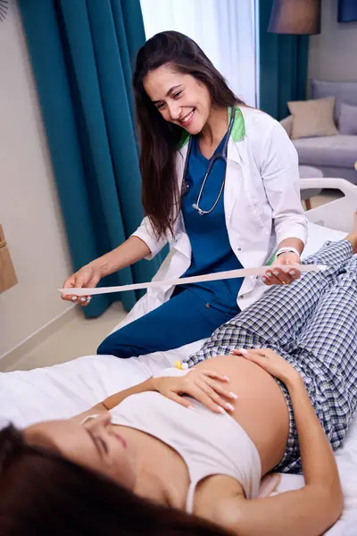 Lächelnde Europäische Krankenschwester Mit Elektrokardiogramm Und Blick Auf Junge Schwangere — Stockfoto
