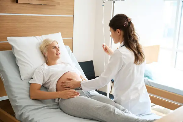 Europäerin Schaut Kaukasische Ärztin Die Ihren Schwangerschaftsbauch Überprüft Und Drop — Stockfoto