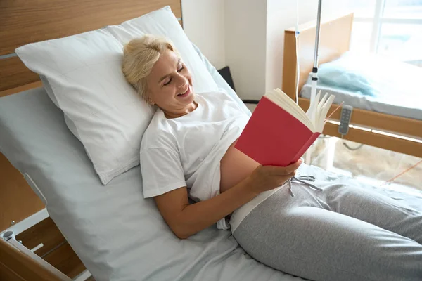 Lächelnde Schwangere Kaukasierin Liest Ihrem Zukünftigen Kind Auf Dem Krankenbett — Stockfoto