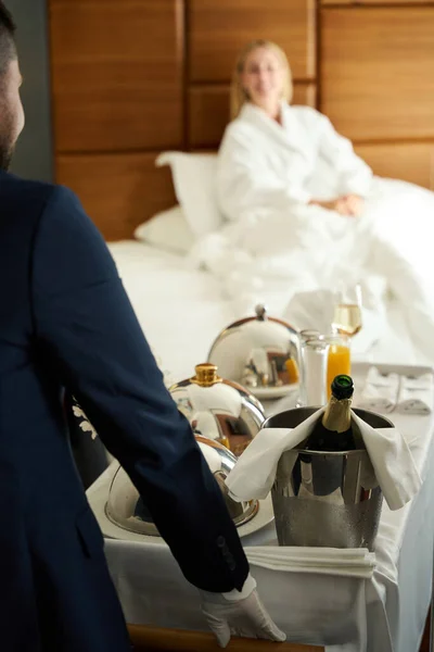 Официант Подает Завтрак Номер Шампанским Столе Гость Отеля Уютном Махровом — стоковое фото