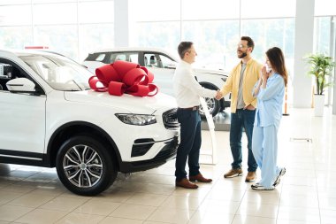 Müdür ve müvekkil el sıkışarak anlaşmayı imzaladılar, koca arabayı sevgili karısına verdi.