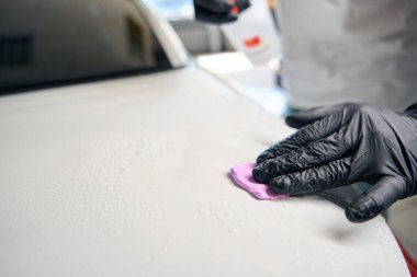 Araba bakımına özel kil sürme işlemi, bir tamirci sprey tabanca kullanır