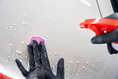 Araba bakımına özel kil sürme işlemi basit. Tamirci sprey şişesi kullanır.