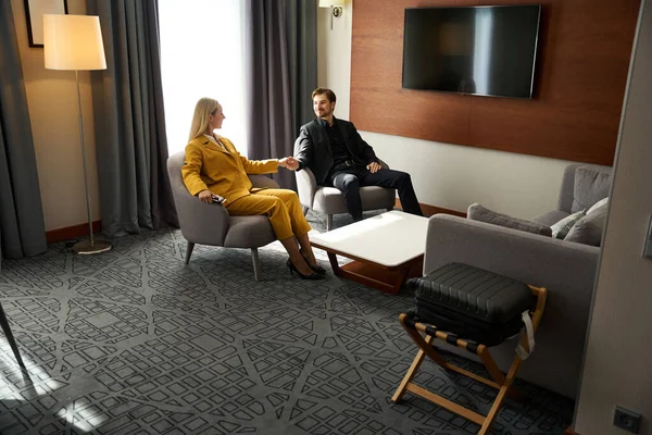 Çift yoldan önce bir otel odasında dinleniyor, sarı takım elbiseli bir kadın.