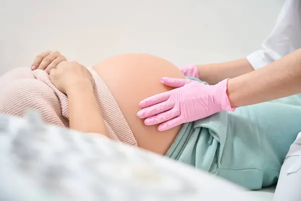 妊娠2学期の女性の腹を検査する医療手袋の認定婦人科医 赤ちゃんのプレゼンテーションをチェック — ストック写真
