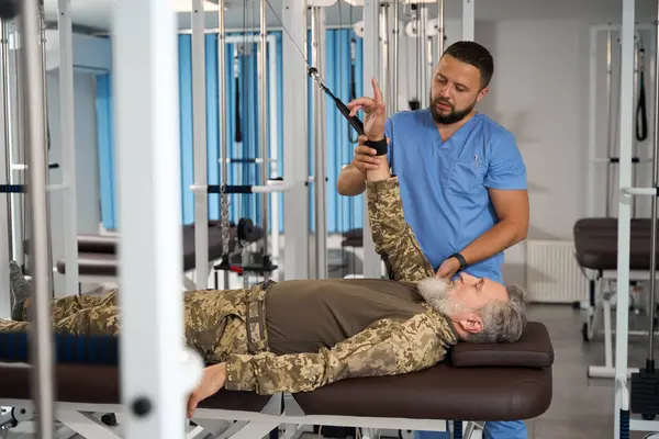 Rehabilitationstherapeut Hilft Einem Patienten Übungen Zur Dehnung Der Armmuskulatur Einem — Stockfoto