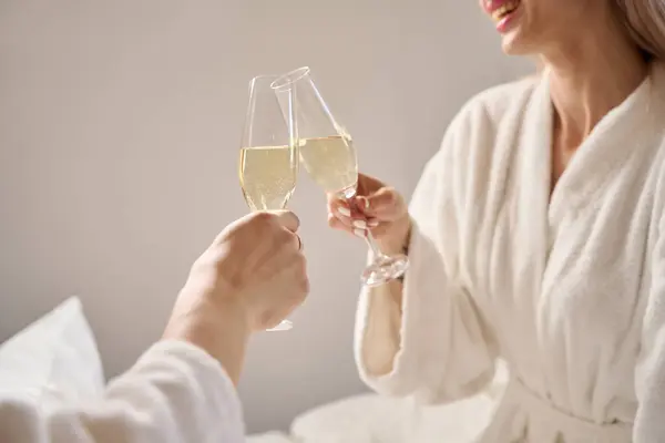 stock image Happy couple with a glass of champagne, people in fluffy bathrobes