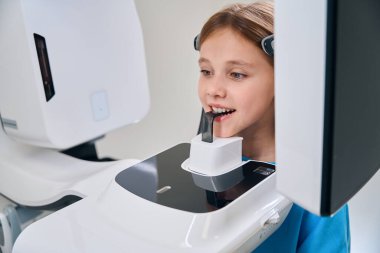 Diş röntgeni çekilen kız, modern ekipman kullanılıyor