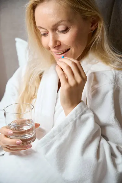 Pleased Lady Bathrobe Seated Bed Glass Water Hand Lifting Drug — Stock Photo, Image