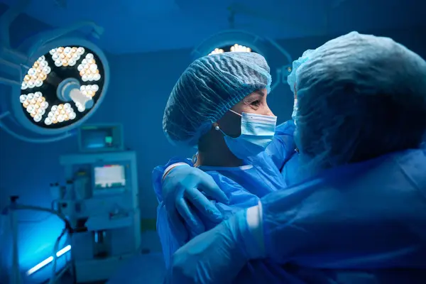 Médicos Cirúrgicos Comemorando Operação Bem Sucedida Abraços Sala Cirurgia — Fotografia de Stock