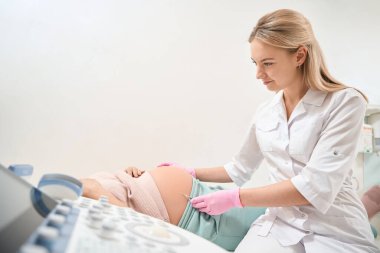 Kadın jinekolog Rh immünoglobülin enjeksiyonu yapıyor. Rh uyumsuzluğu ihtimali yüzünden.