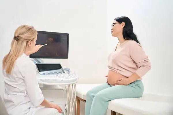 Specjalnie Przeszkolony Terapeuta Wyjaśniający Kobiecie Ciąży Etapy Rozwoju Dziecka Zabiegu — Zdjęcie stockowe