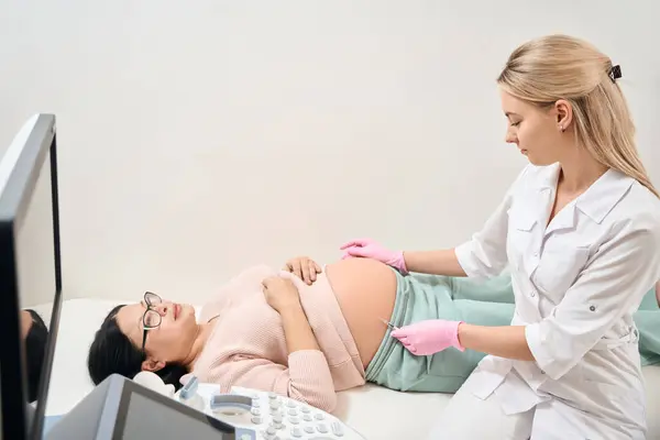 Kvalifikovaná Zdravotní Sestra Podávající Injekci Těhotné Ženě Která Leží Gauči — Stock fotografie