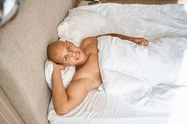 非洲裔美国人躺在床上 在酒店房间里看着相机的头像 休假和旅行的概念 — 图库照片