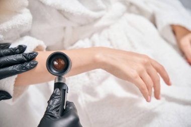 Kadın güzellik uzmanının el derisini güzellik salonunda kadın dermatoskopuyla incelemesi. Vücut bakımı kavramı