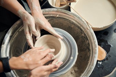 Seramik atölyesinde çömlekçi çarkında kille çalışan tanınmayan kadınlar.