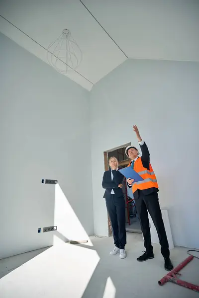 Pełna Długość Zdjęcia Klientki Architekta Stojącego Niedokończonym Pomieszczeniu Podczas Inspekcji — Zdjęcie stockowe