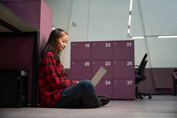 Молодая Сконцентрированная Азиатка Работница Использует Ноутбук Полу Шкафом Коворкинг Офисе — стоковое фото