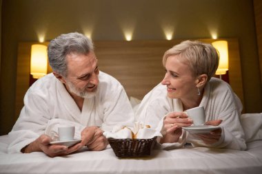 Kafkasyalı mutlu bir çiftin, fincanlardan çay ya da kahve içmelerini ve otel odasında birbirlerine ışıkla bakmalarını ön plana çıkarmak. Dinlenme, tatil ve seyahat. İlişki