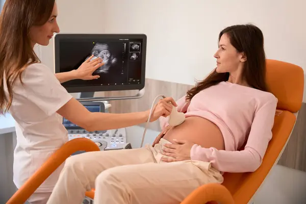 Female Doctor Moving Ultrasound Probe Pregnant Womans Stomach Hospital — Stock Photo, Image