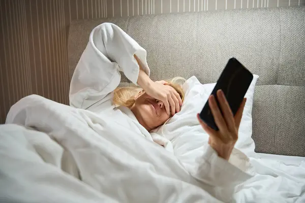 Tired Woman Covering Her Eyes Hand While Lying Bed Cellphone — Stock Photo, Image