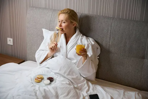 Tranquil Mujer Sentada Cama Habitación Hotel Con Vaso Jugo Naranja — Foto de Stock