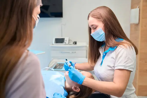 Médico Realiza Procedimentos Odontológicos Paciente Jovem Usando Instrumentos Especiais — Fotografia de Stock