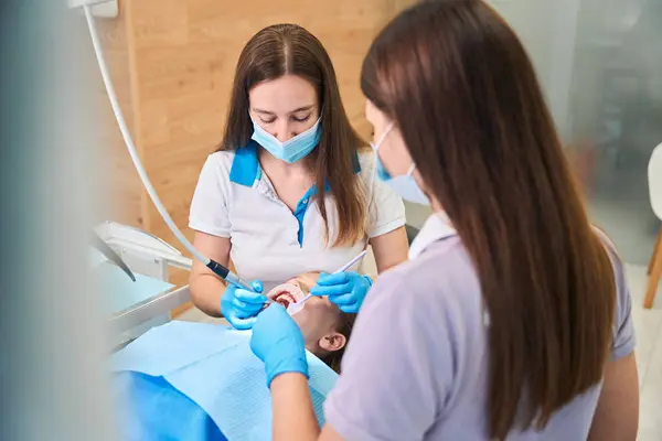 Woman Dentist Treats Teeth Teenage Girl Assistant Helps Doctor — Stock Photo, Image