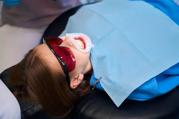 Nastolatka Leży Fotelu Dentystycznym Nosząc Zwijacz Dentystyczny Okulary Ochronne — Zdjęcie stockowe