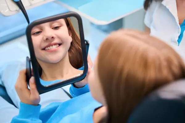 Jovem Paciente Admira Seu Sorriso Dentes Brancos Espelho Menina Está — Fotografia de Stock