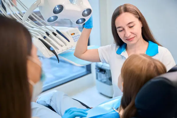 Zahnarzt Beginnt Eine Junge Patientin Untersuchen Das Sweatshirt Der Mädchen Stockfoto