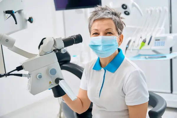 Qualifizierte Zahntherapeutin Schutzmaske Mit Mikroskop Die Zahnkanäle Füllen Bereitstellung Qualitativ Stockfoto