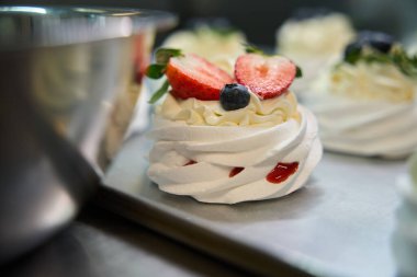 Tatlı ve lezzetli mini Pavlova tatlısına bakın. Çıtır kremalı ve taze meyve kremalı. Üstünde krema var.