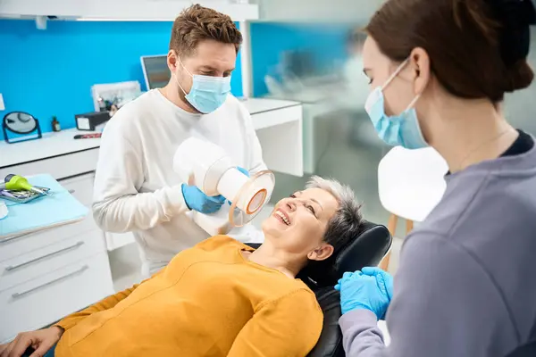 휴대용 도구를 엑스레이를 만드는 그녀의 치아를 보여주는 소파에 성숙한 감염에 — 스톡 사진