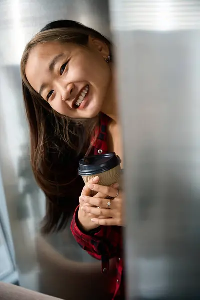 Gestutzte Junge Lächelnde Asiatische Mitarbeiterin Mit Kaffeetasse Die Verschwommenem Coworking Stockbild