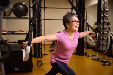 Spor kıyafetleri ve spor gözlük takan beyaz kadın spor salonunda spor ipleriyle spor egzersizi yapıyor. Modern sağlıklı yaşam tarzı kavramı