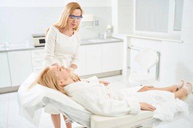 Plasmolift enjeksiyonlarını yapmak, cildini gençleştirmek ve doğal yenilenme sürecini tetiklemek için kozmetik muayenehanesine giden kadın müşteri.