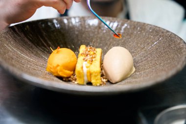 Kısmi erkek şefin el dekorasyonu yaprağının seçici odağı. Restorandaki masada, tabakta kurabiyeyle cımbız. Lezzetli sağlıklı yemek kavramı