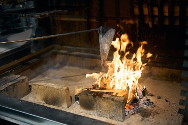 Restoranda yanan şöminede demir üçgen tencerede yemek kızartıyorum. Lezzetli sağlıklı yemek kavramı