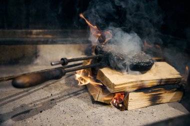 Lokantada yemek pişirmeden önce yanan ocakta, ağaçların üzerinde gözleme yapan seçici kişi. Lezzetli sağlıklı yemek kavramı