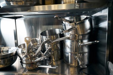 Modern restoranda metal tencere ve kâselerle dolu bir masa. Lezzetli sağlıklı yemek kavramı