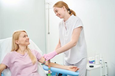 Dost canlısı hemşirelere gülümseyen bayan hastalar kan bağışına, rutin sağlık kontrolüne, tıbbi laboratuvarda kan grubu kararlılığına, klinik araştırmalara hazırlanıyor.
