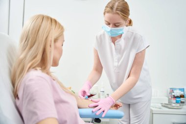 Nitelikli kadın laboratuvar çalışanının kan örneğini boş alan, sağlık kontrolü yapan, biyokimyasal kan testi için sezonluk satış yapan, klinik araştırmalar yapan kadın hasta.