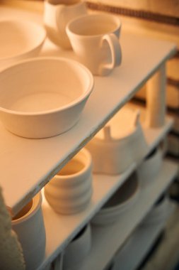 Çamur seramik bardaklar atölyede çömlek fırlatmak için fırına konur.