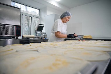 Üniformalı işçiler krep ve modern ekipmanları yarı bitmiş ürünler atölyesine koyarlar.