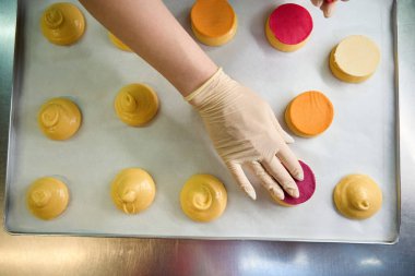 Kaliteli bir pastacı choux hamurunun üstüne Craquelin 'den renkli mermiler koyarak lezzetli ve huysuz Choux au Craquelin hazırlıyor.